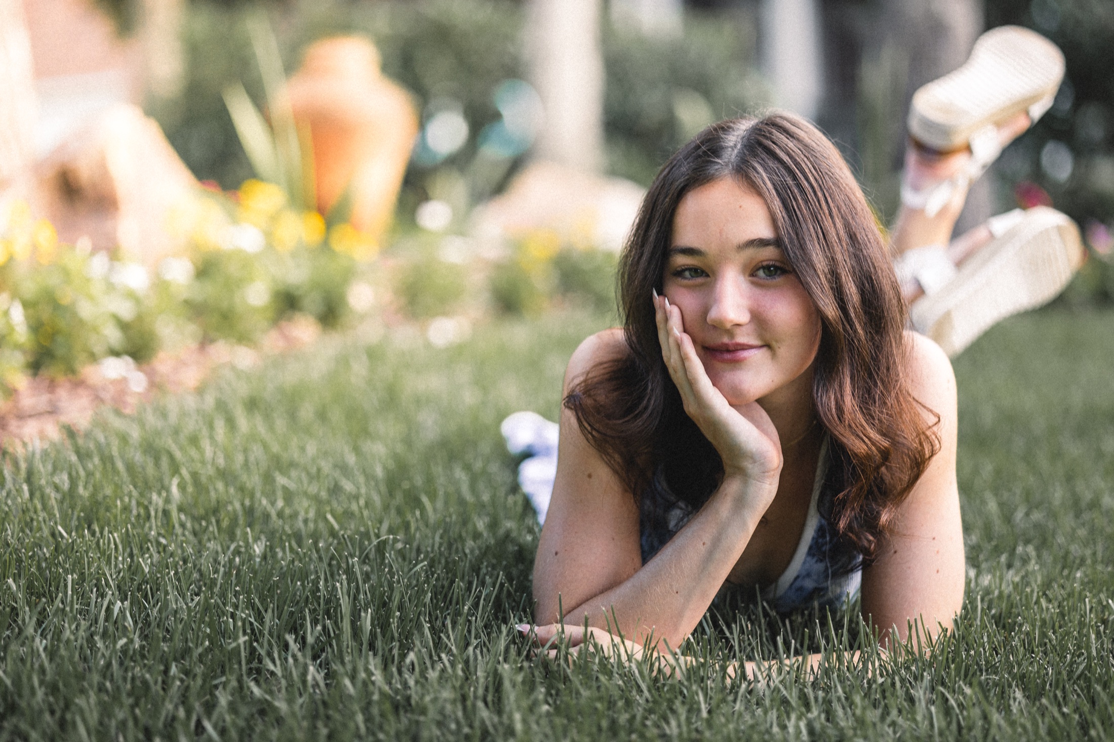 Emma Jolliff lying in the grass in a blue floral dress