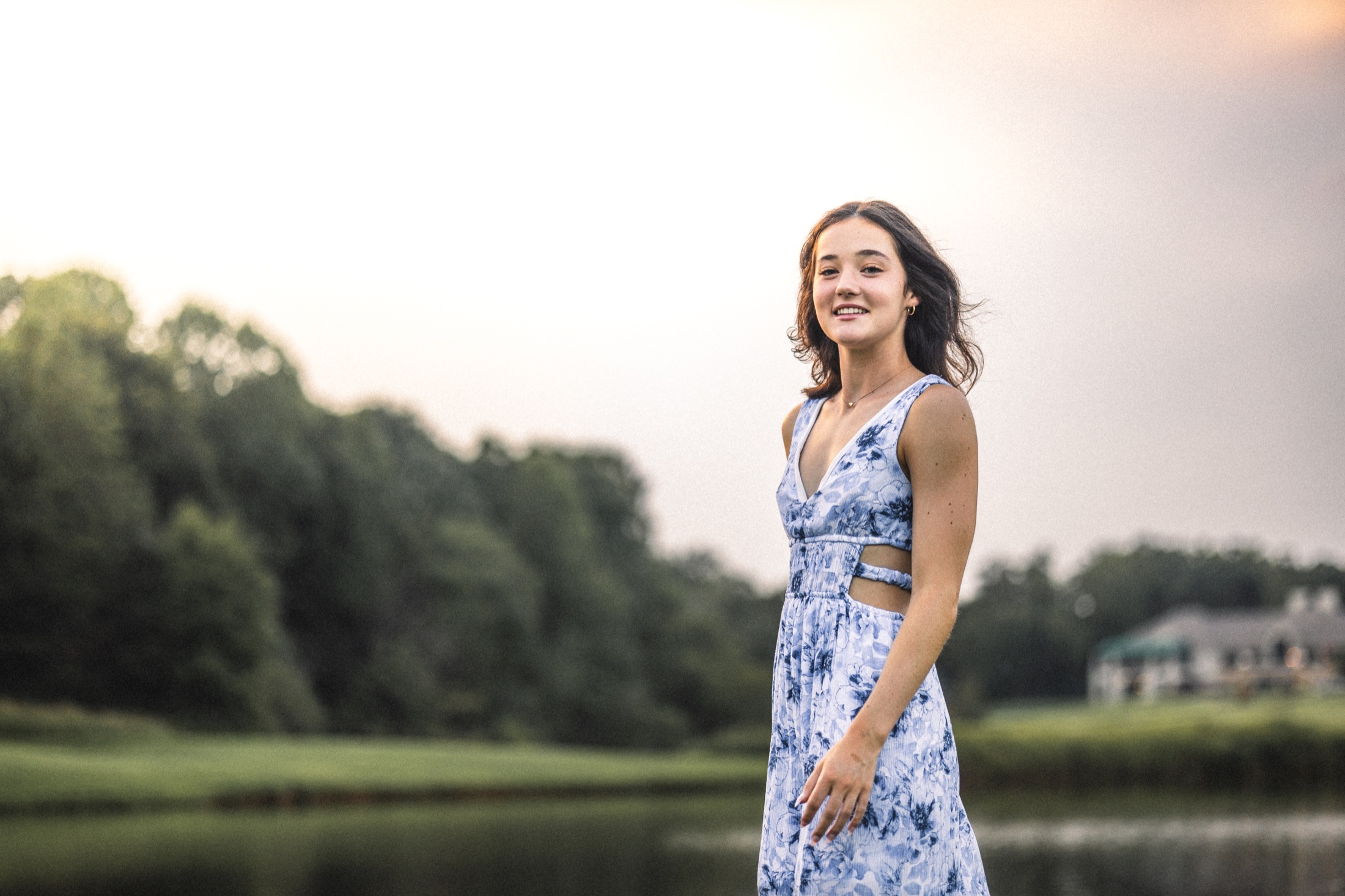 Emma Jolliff walking beside a pond in a blue floral dress